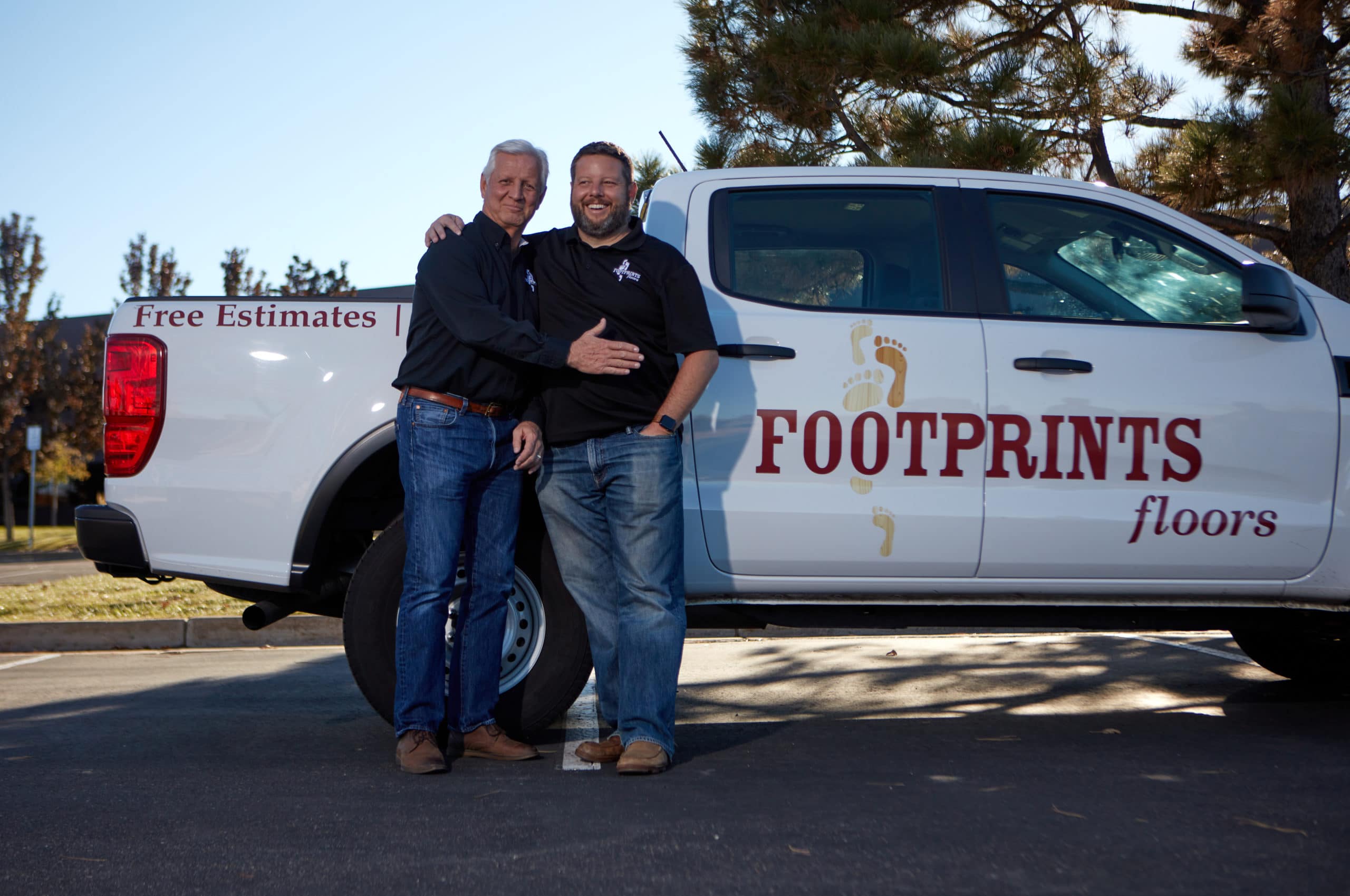 Footprints Floors semi-absentee franchise owner standing in front of truck.