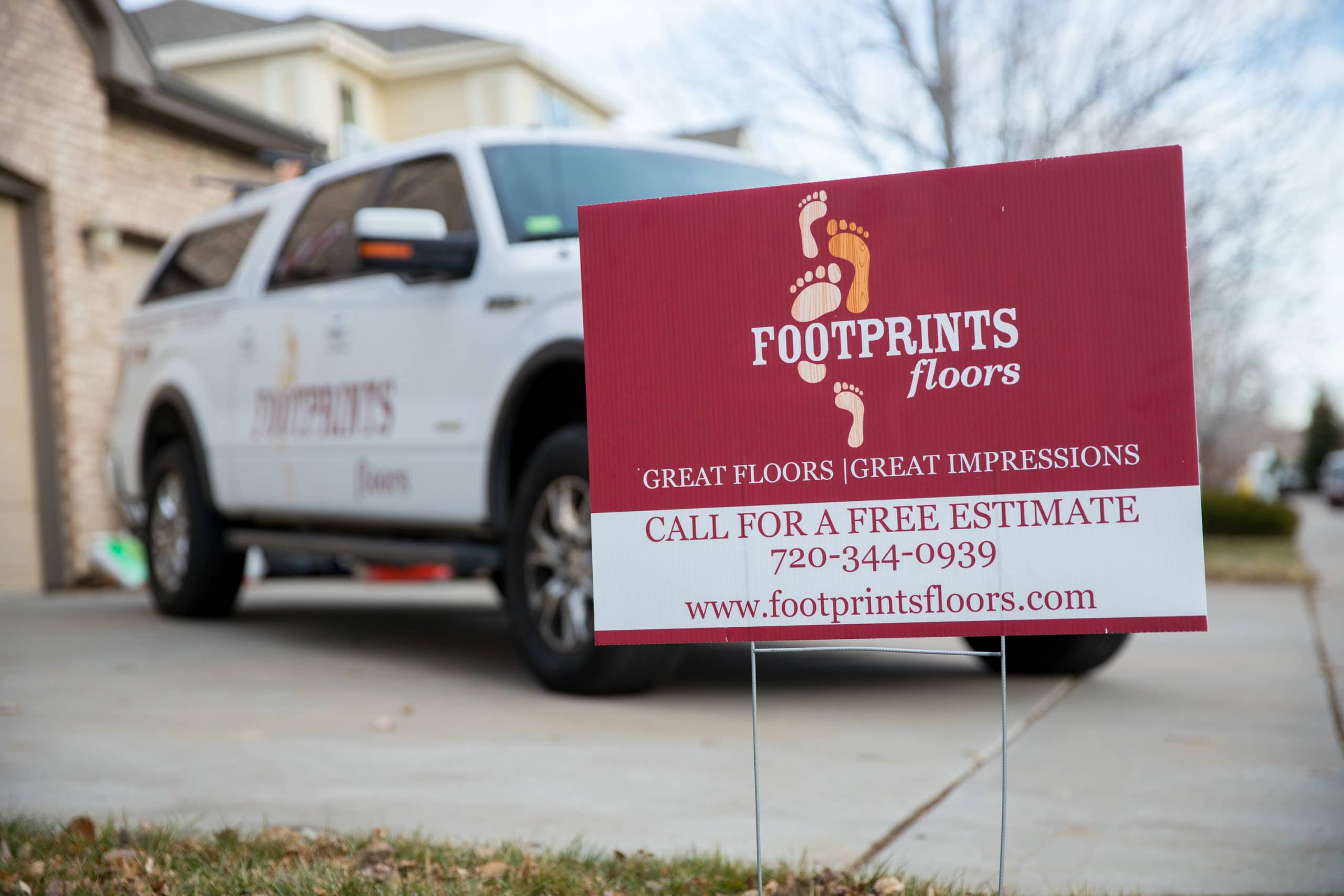 Footprints Floors home improvement franchise sign in front yard showing the economic stability.